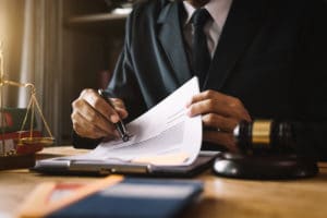 Lawyer reviews documents with a gavel and scales of justice on the desk, Masri.